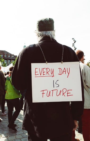 Signore con cartello “Every day is future”